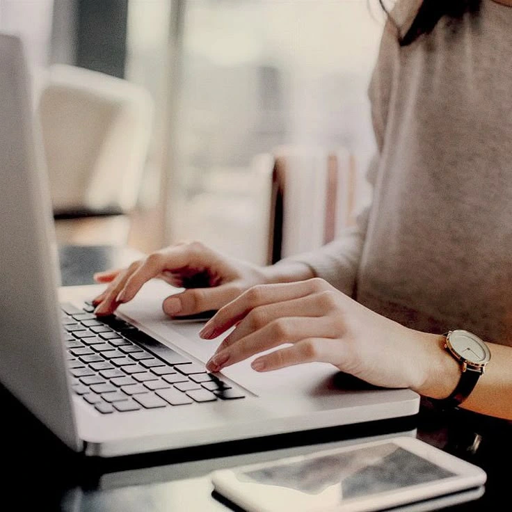 Hands typing on a laptop keyboard with a wristwatch. Best Freelance Digital Marketing Consultant in Kannur