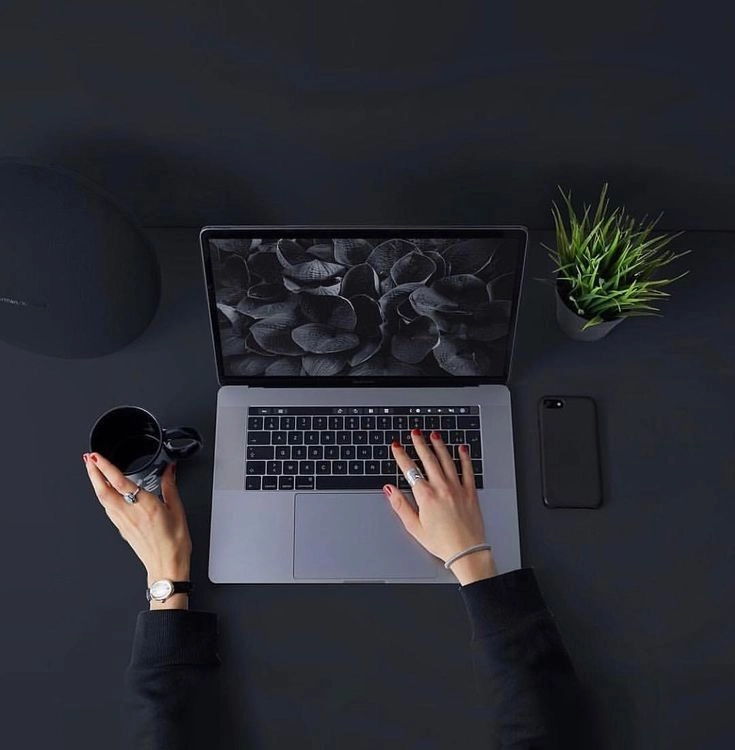 Person typing on a laptop with coffee and plant. Freelance Digital Marketer in KannurKerala
